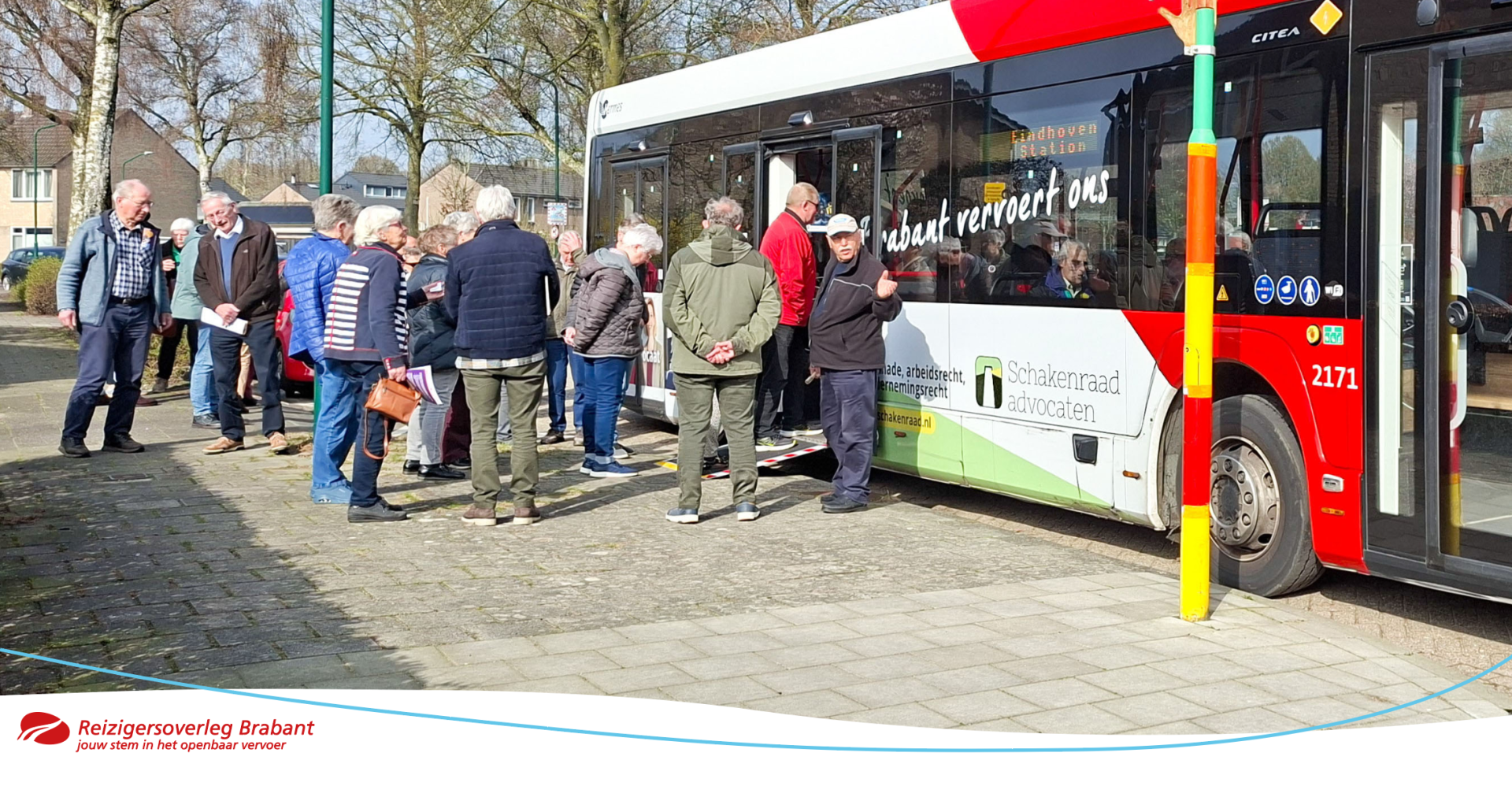 Een OV-gids geeft uitleg aan ouderen over reizen met de bus
